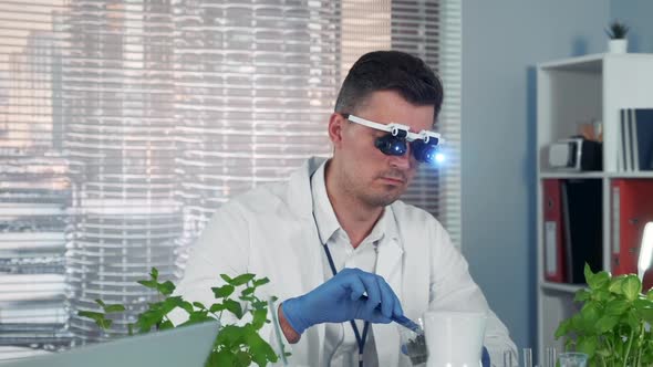 Botanist in Magnifying Glasses Learning Some Type of Plant in Big Modern Lab