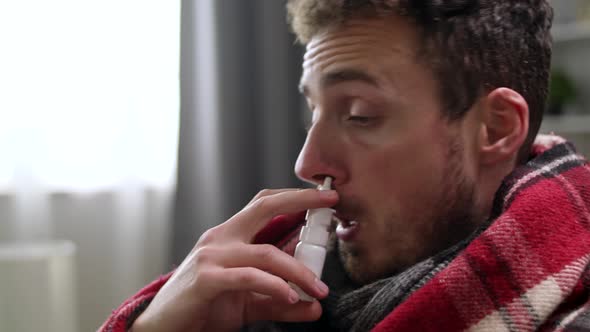 Ill Man Uses Nasal Spray on Sofa in Living Room