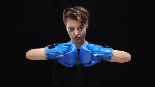 Portrait of Confident Young Woman Bumping Fists in Boxing Gloves Looking at Camera