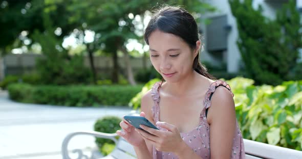 Woman Use of Mobile Phone Online in The Park