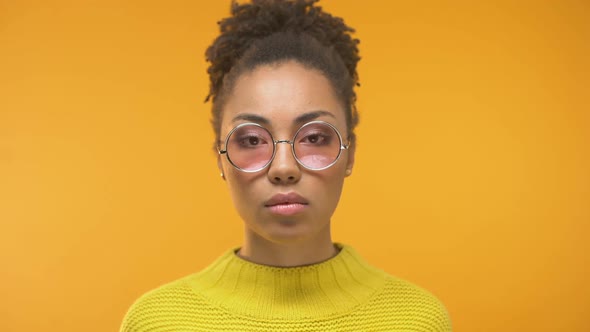 Young Black Woman Looking Closer in Mirror, Noticing First Wrinkles, Skin Care