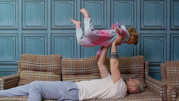 Child Girl Playing Game Laughing Having Fun with Father Happy Dad Lifting Small Kid Daughter Up