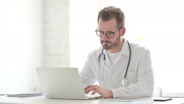 Doctor Working on Laptop in Office