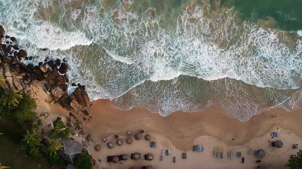 Aerial over idyllic Sri Lanka Beach. Palm trees and waves on sand beach. Tangalle, Sri Lanka