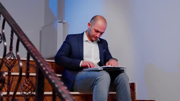 Office Manager Reading Raport Sitting on Stairs