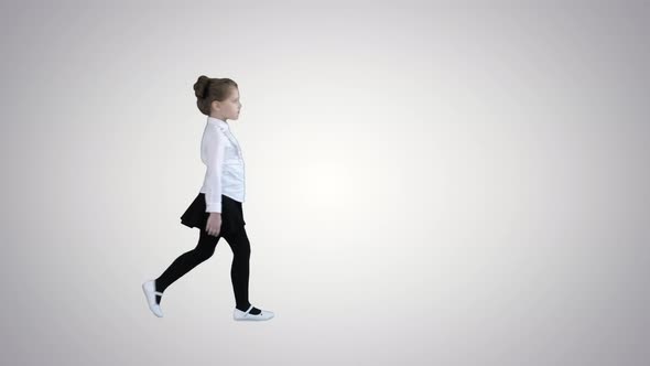 Little Girl in School Uniform Walking By on Gradient Background.