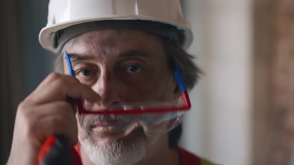 Portrait of Mature Builder with Dirty Face on Construction Site