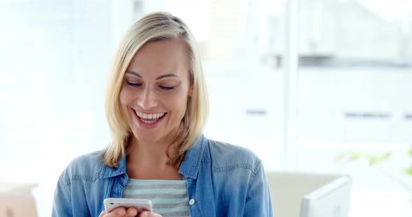 Businesswoman text messaging on mobile phone