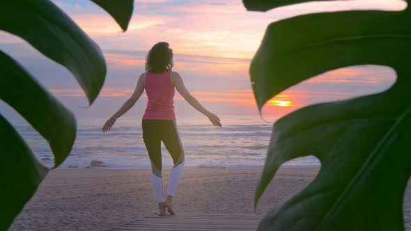 Woman Doing Yoga on Wooden Walkway