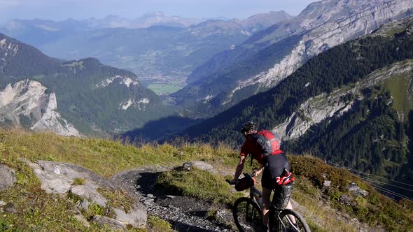 A man mountain biking across a European mountain range