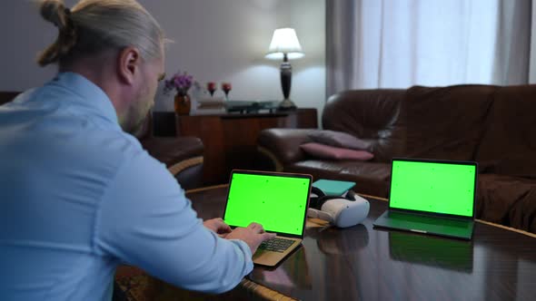 Two Chromakey Laptops with Web Page Mockup and Caucasian Man Typing Messaging Online