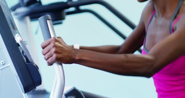 Fit woman exercising on cross trainer