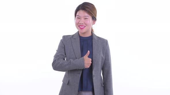 Happy Young Asian Businesswoman Giving Thumbs Up