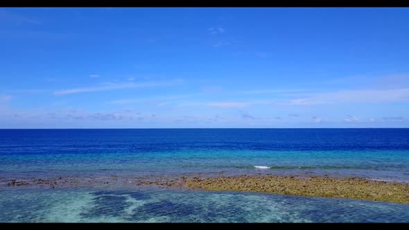 Aerial drone seascape of idyllic coastline beach lifestyle by clear sea with bright sandy background