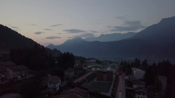 Aerial view of Levico Terme, Italy during sunrise with drone flying forward