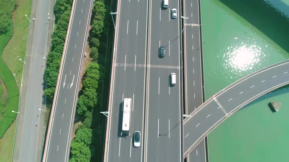 Aerial Top Down Tilt View of a Highway Overpass Multilevel Junction with Fast Moving Cars Surrounded