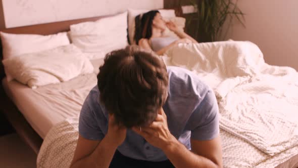 Upset couple ignoring each other after fight on bed