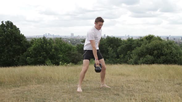 Male exercising with cow bell in park