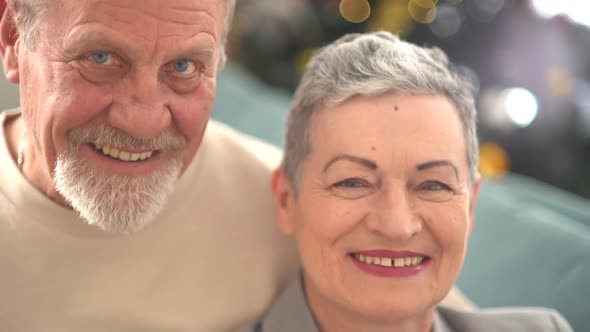 Close Portrait of Smiling Elderly Husband and Wife Looking at Camera
