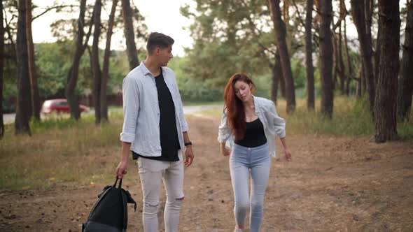 Exhausted Dissatisfied Woman Arguing with Man Walking with Backpack in Forest