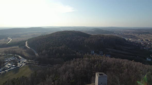 A rearward aerial drone shot of the mountain landscapes in Poland while revealing the Chęciny Royal