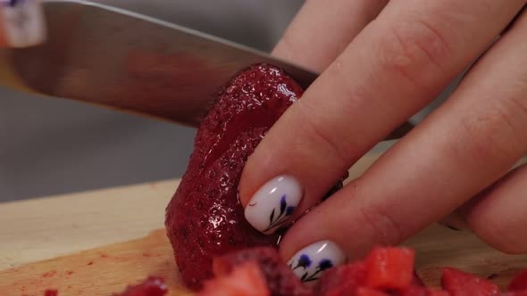 Close-up of Woman Hands Cutting Strawberries on Cutting Board.