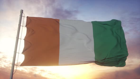 Flag of Cote D'ivoire Waving in the Wind Sky and Sun Background