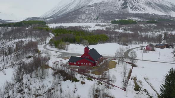 Red church in Olderdalen, Norway. Overcast winter weather.4K aerial drone shot with a slow sideways