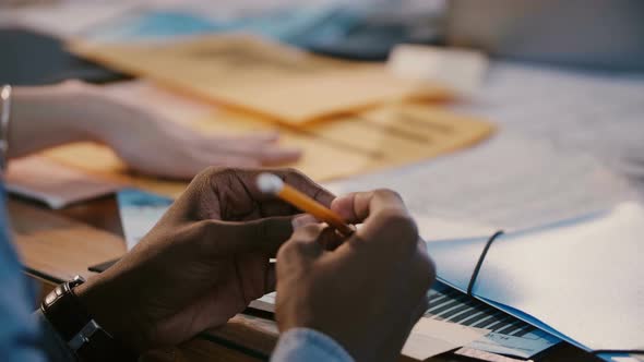 Close-up Shot, Hands of African American Office Worker Holding Pencil, Stressed at Team Meeting