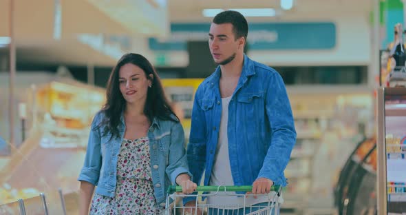 Young Man and Woman Walk Through a Grocery Cart and Look at the Goods in the Shop Windows / Videohive