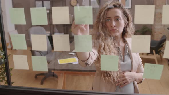 Long-haired Woman Writing on Sticky Note