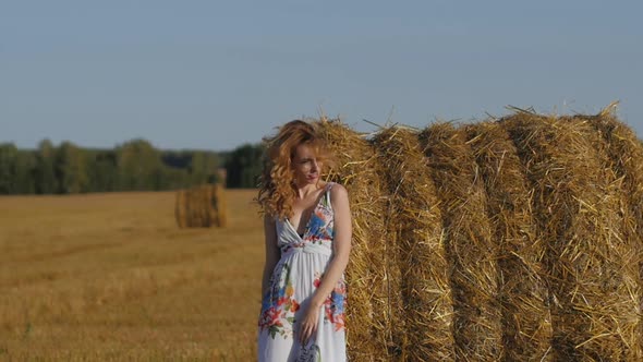 Portrait of Attractive Redhead Woman Dancing Against Background of Fields