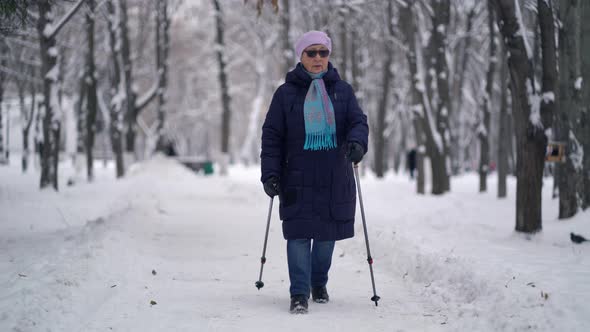 Active Senior Elderly Woman Training Nordic Walking with Trekking Poles. Elderly Woman Practicing