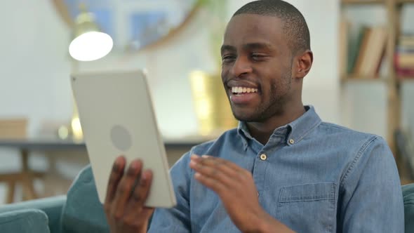Video Call on Tablet By Young African Man