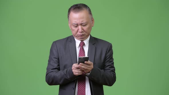 Mature Japanese Businessman Using Phone