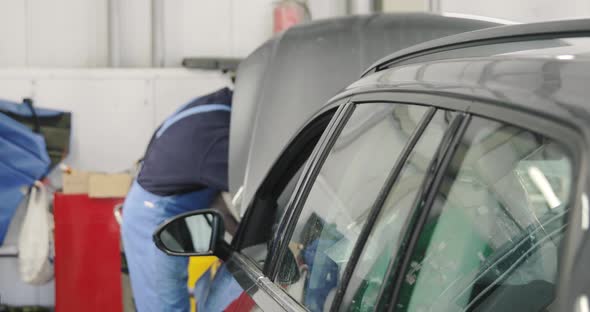 Mechanic Working On Car Engine Bay In The Dealer Car Service