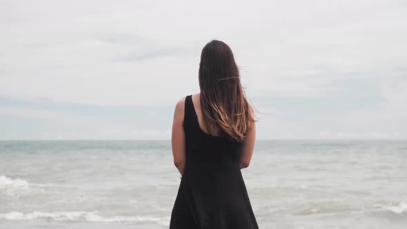 Girl In Black Dress Lookig At The Sea