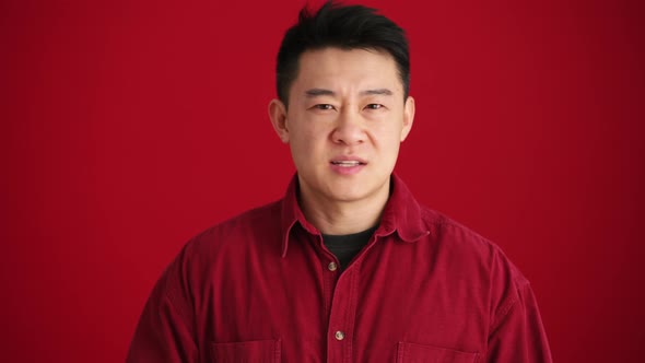 Concentrated Asian man wearing shirt showing no gesture