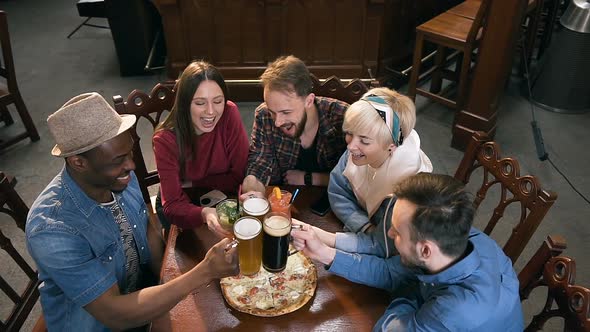 Company of Young Hipster Friends Clinking Glasses with Beer