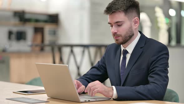 Denying Businessman with Laptop Saying No with Finger Sign