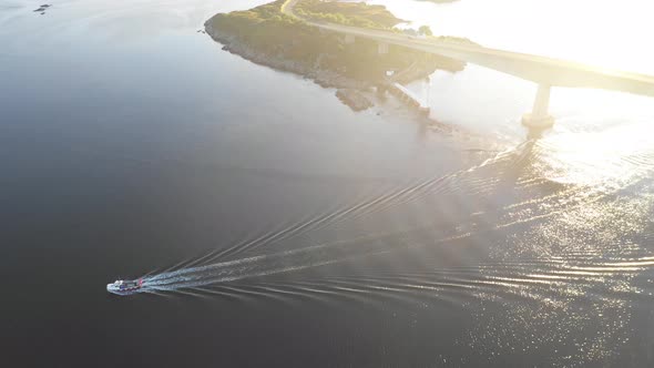 Aerial top down view of a boat at sea in Scotland with beautiful water at sun