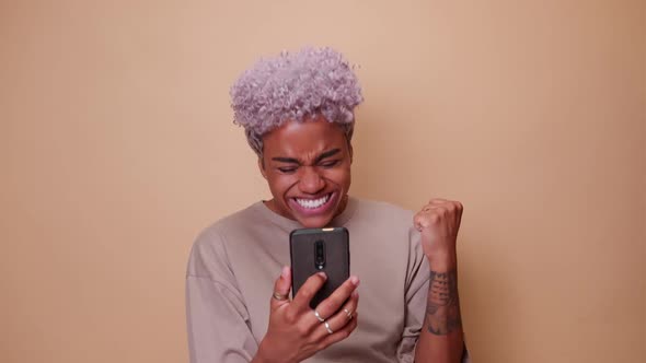 Young African American Woman Overjoyed to Receive Message in Mobile Phone