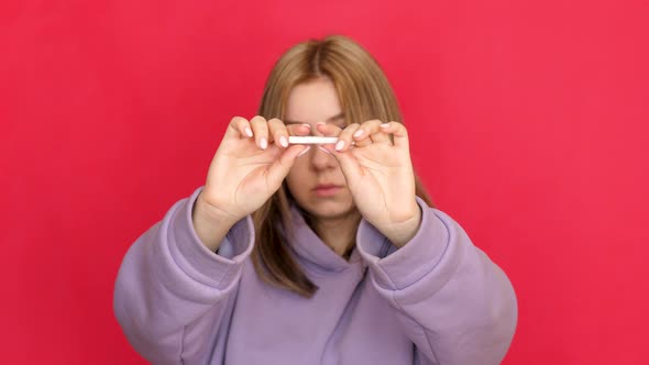 Attractive Caucasian young brunette woman 21 years old breaks a cigarette looks at the camera. stage