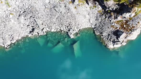 drone view above deep blue crystal clear mountain lake water in a swiss lake