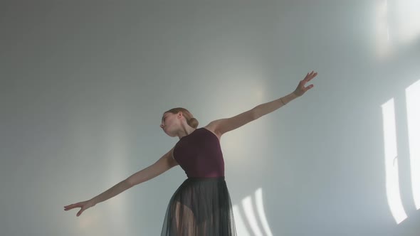 The Ballerina Performs Smooth Movements with Her Hands in Rehearsal, Performing in a Studio Bathed