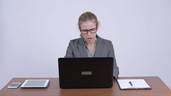 Young Stressed Blonde Businesswoman Using Laptop and Getting Bad News at Work