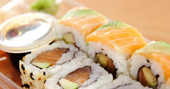 Sushi rolls with salmon in plastic container