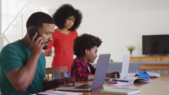 Mother helping son to use laptop at home