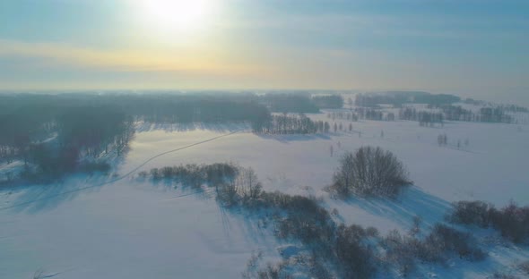 Aerial View of Cold Winter Landscape Arctic Field Trees Covered with Frost Snow Ice River and Sun