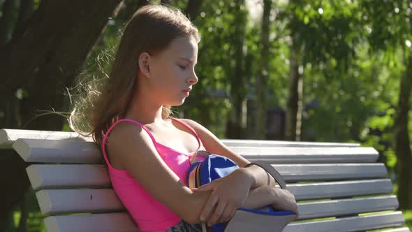 Sad Lonely Teenage Girl Sitting on Bench and Crying in Park